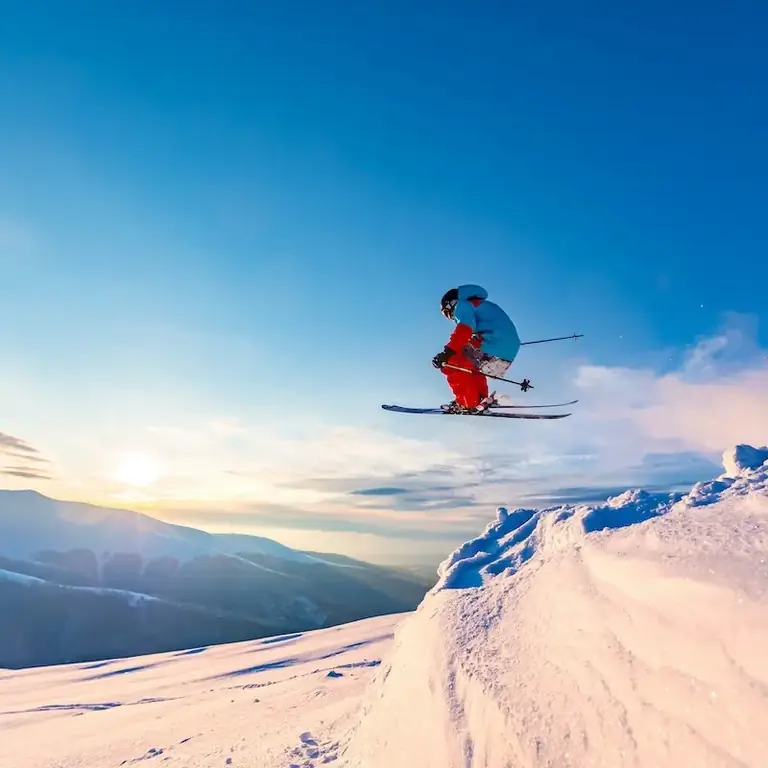 лыжник прыгает во время заката
