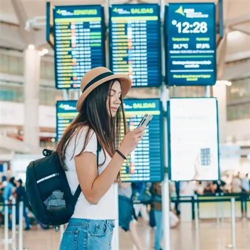 Женщина проверяет телефон в аэропорту