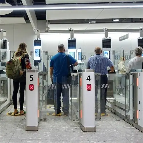 Путешественники сканируют свои паспорта в eGates для автоматизированного пограничного контроля и международных поездок