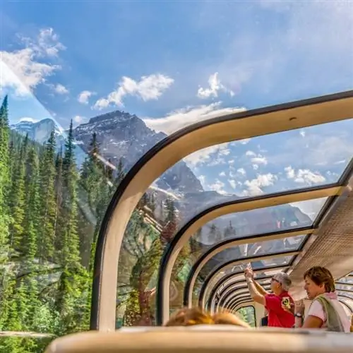 Пассажиры смотрят в окна стеклянного купола поезда Rocky Mountaineer, проходящего через канадские Скалистые горы.