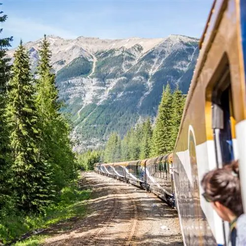 Женщина смотрит на Скалистые горы со смотровой площадки на поезде Rocky Mountaineer