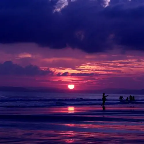 Розовый и фиолетовый закат над пляжем Радханагар в Индии.