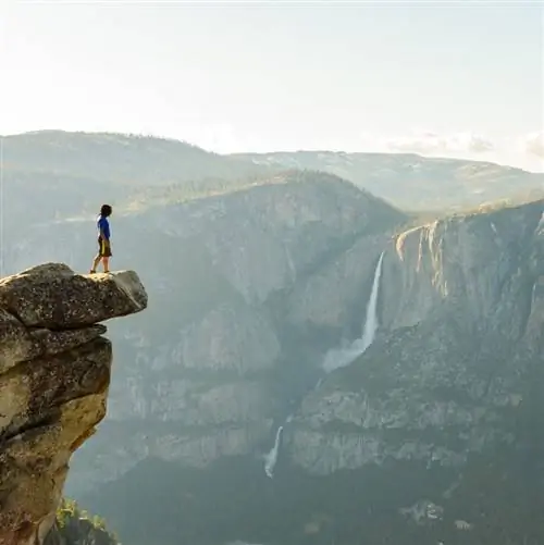 Турист смотрит на водопад Йосемити с ледника в парке Йосемити