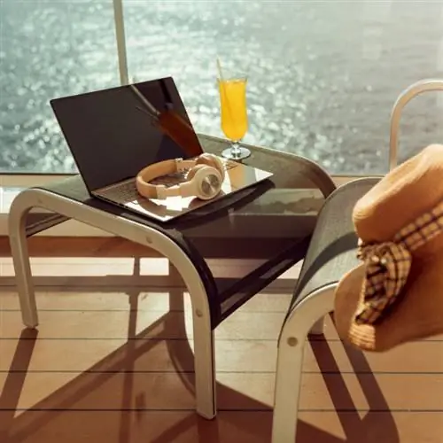 Ноутбук и наушники сидят на маленьком столике на балконе круизного лайнера