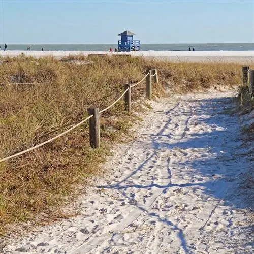 Дорожка к пляжу с белым песком и станции спасателей на пляже Сиеста-Ки недалеко от Сарасоты, Флорида.