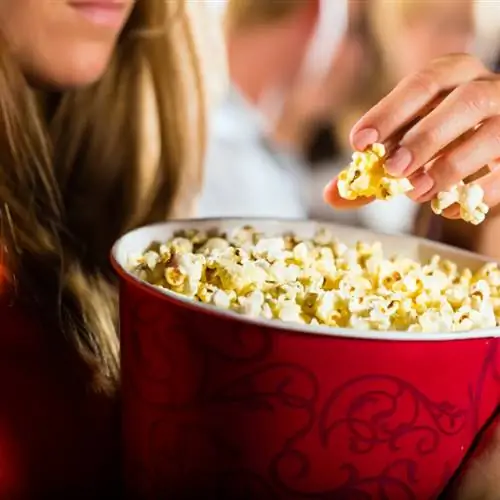 Девушка ест попкорн в кинотеатре