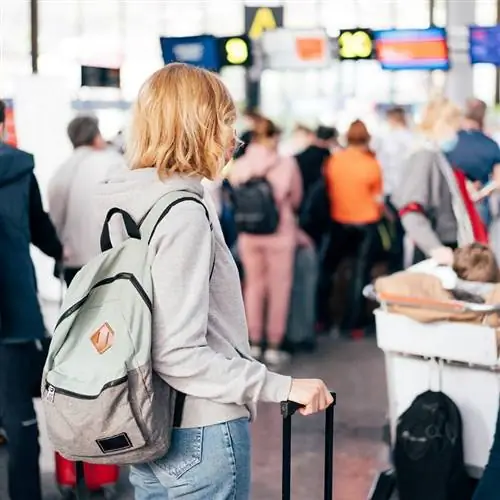 Женщина-путешественница, регистрирующаяся на рейс в аэропорту, авиаперелет