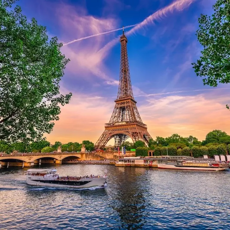 Париж Эйфелева башня и река Сена на закате в Париже, Франция. Эйфелева башня - одна из самых знаковых достопримечательностей Парижа.