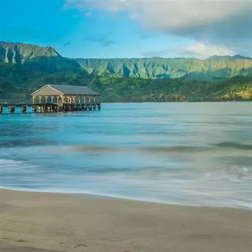 Пляж Ханалей Бэй на Гавайях, окруженный пышными зелеными горами