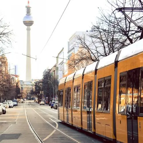 Желтый трамвай проходит по улицам Берлина, Германия.