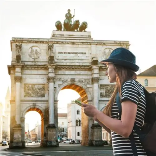 Женщина-путешественница стоит перед Триумфальной аркой в Мюнхене, Германия.