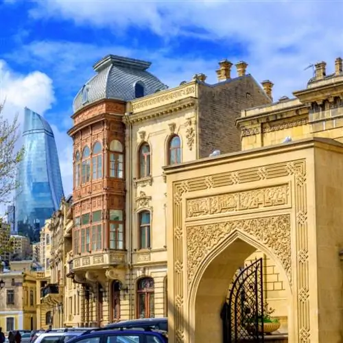 Панорамный вид на Старый город Баку (Ичери Шехер), Азербайджан, с современным стеклянным небоскребом Пламенная башня на заднем плане