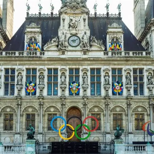 Олимпийские кольца выставлены перед богато украшенным зданием в Париже.