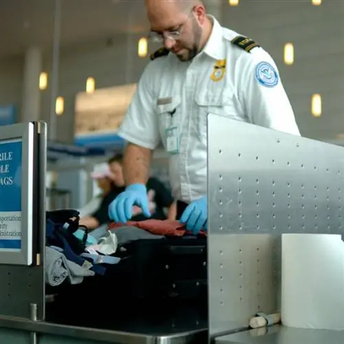 Сотрудник TSA обыскивает чей-то багаж в аэропорту