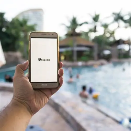 использование приложения Expedia в бассейне отеля