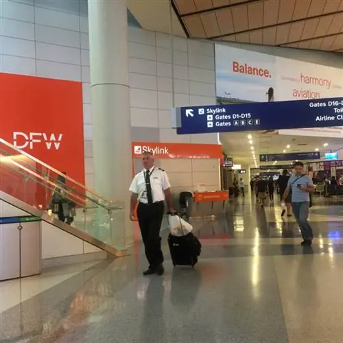 пилот идет в аэропорту DFW