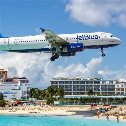 Крупный план самолета JetBlue, пролетающего над пляжной зоной в Синт-Мартине, в голландском Карибском море, Королевство Нидерланды Крупный план самолета JetBlue, пролетающего над пляжной зоной в Синт-Мартине, в голландском Карибском море, Королевство Нидерланды