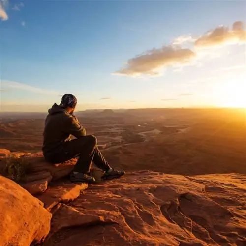 Путешественник наблюдает закат над Гранд-Каньоном