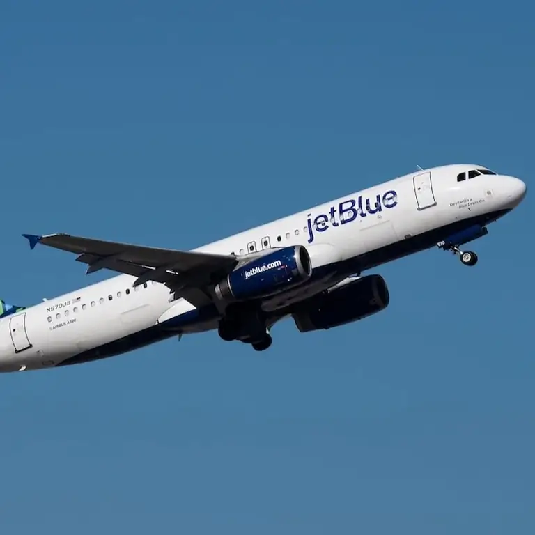 Самолет JetBlue летит в голубом небе