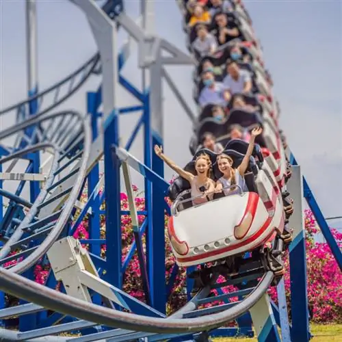 Счастливые друзья в парке развлечений в летний день.