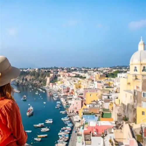 женщина в шляпе смотрит на землю и море острова Прочида, Неаполь, Италия.