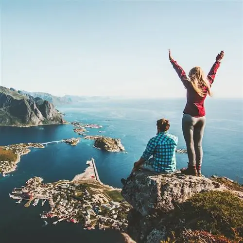 Пара семей, путешествующих вместе на краю скалы в Норвегии, мужчина и женщина, концепция образа жизни, летние каникулы, вид с воздуха на открытом воздухе, Лофотенские острова, вершина горы Рейнебринген