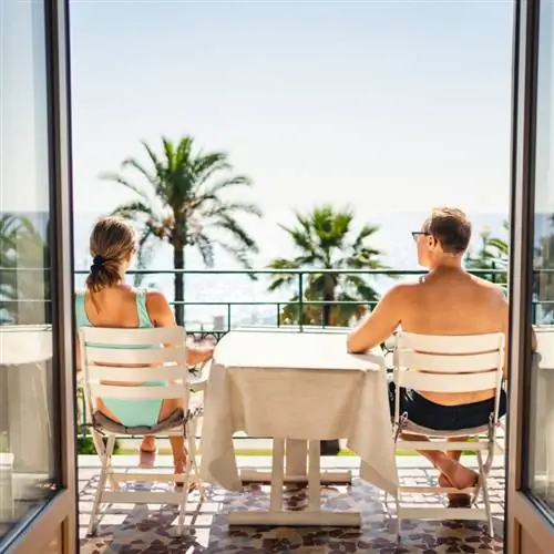 Пара на балконе отеля с видом на пляж