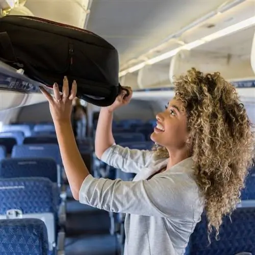 Женщина загружает сумку в самолет