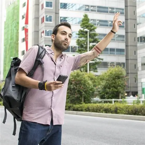 Мужчина машет водителю Убера