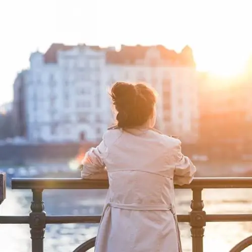 Женщина смотрит на закат в Праге