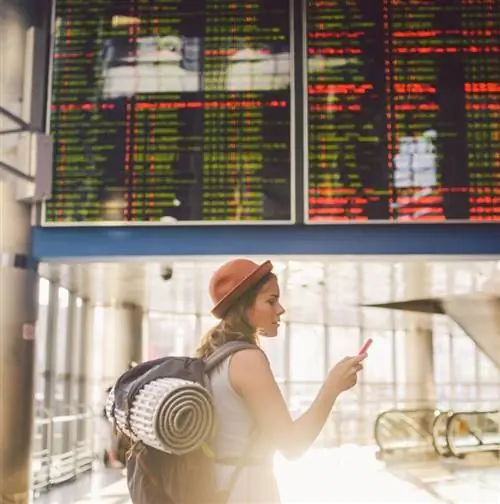 Женщина смотрит в телефон в аэропорту