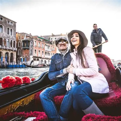 Пара счастливых путешественников, едущих в гондоле в Венеции, Италия