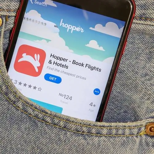 Приложение Hopper, отображающее надпись «бронировать авиабилеты» на телефоне в кармане джинсов человека