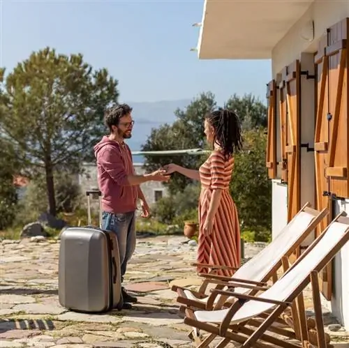 Женщина вручает мужчине ключи на Airbnb