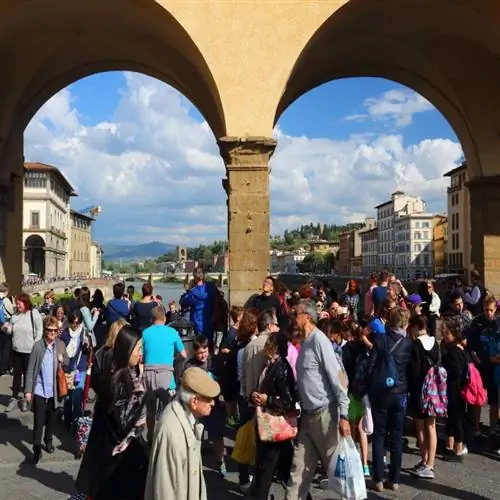 Толпа туристов посещает мост Понте Веккьо во Флоренции, Италия