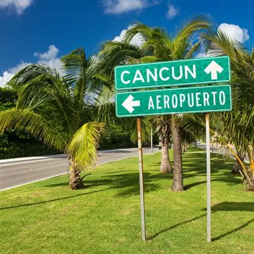 Дорожный знак аэропорта или Канкуна со стрелками на улице в гостиничной зоне в Канкуне, Мексика