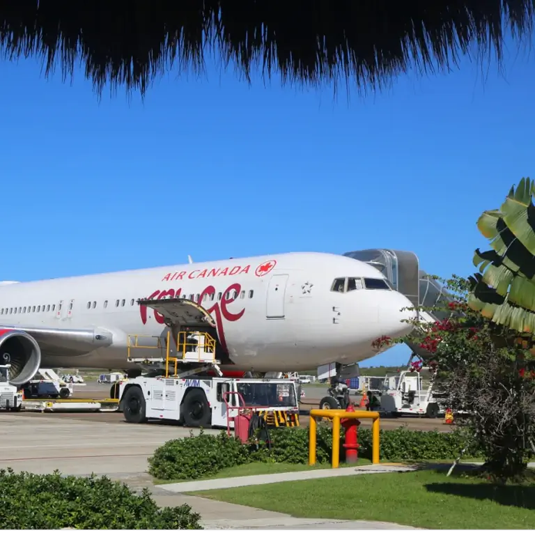 Самолет Air Canada Rouge сидит на тропической взлетно-посадочной полосе