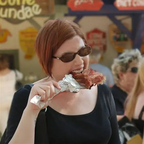 женщина грызет большую ножку индейки