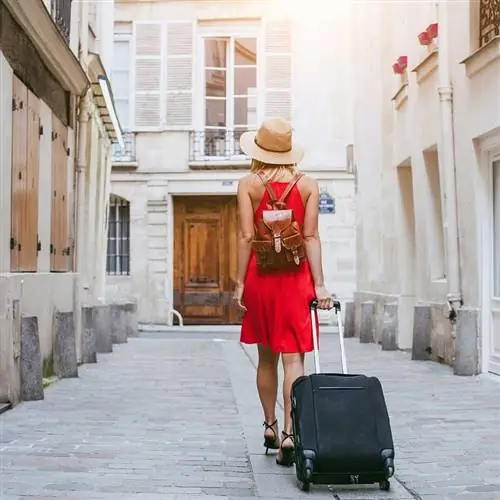 Женщина гуляет с чемоданом по Европе