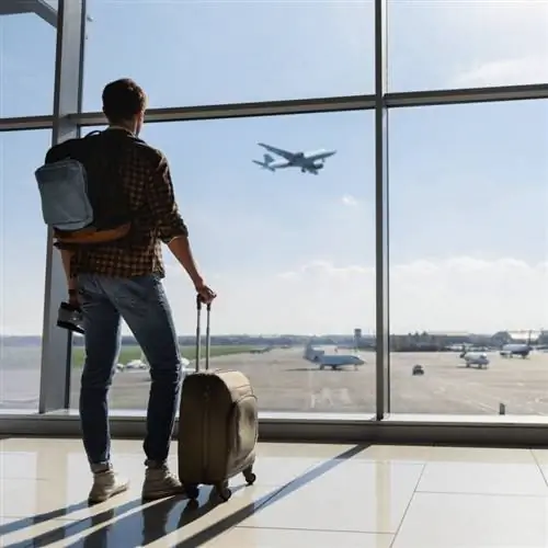 Мужчина смотрит в окно аэропорта