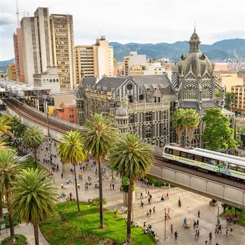 Городская сцена с поездом метро по мосту через исторический центр Медельина, в департаменте Антиокия, Колумбия, Южная Америка