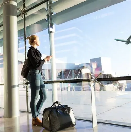 Женщина смотрит в окно в аэропорту