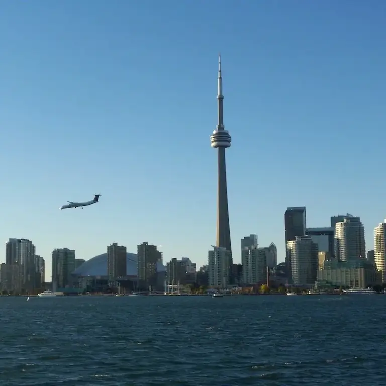 Самолет пролетает над центром города Торонто, Онтарио, Канада, вид на горизонт с озера Онтарио