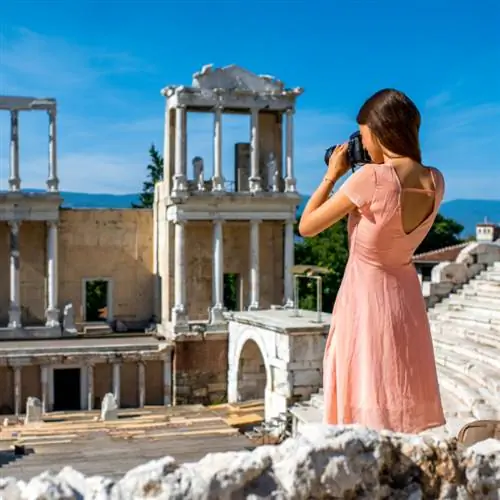 женщина-туристка фотографирует древний театр в Пловдиве, Болгария