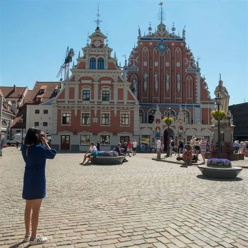 Женщина-туристка фотографирует архитектуру в стиле модерн в Риге, Латвия, на Балтийском побережье Северо-Восточной Европы