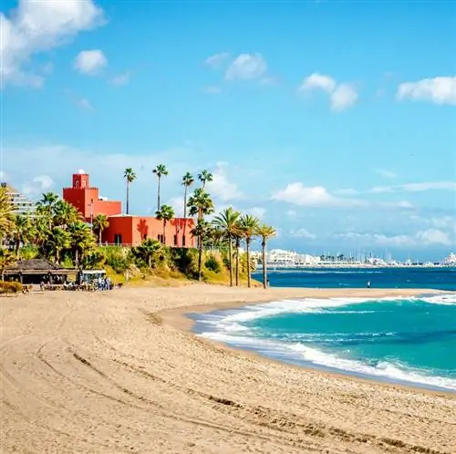 пляж с гладким песком и красным зданием