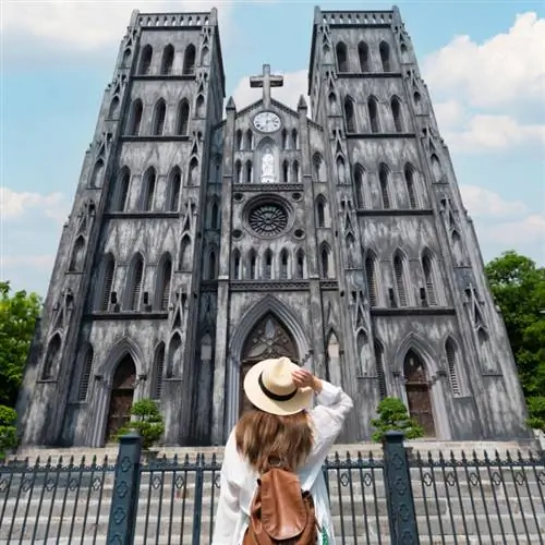 Женщина смотрит на здание в Ханое, Вьетнам.