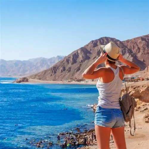 Женщина-туристка-одиночка-путешественница в Дахабе Египте на пляже на Синайском полуострове