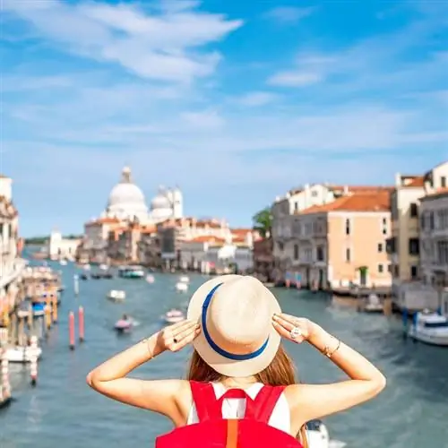 Туристка держит шляпу и смотрит на Большой канал в Венеции, Северная Италия, Южная Европа