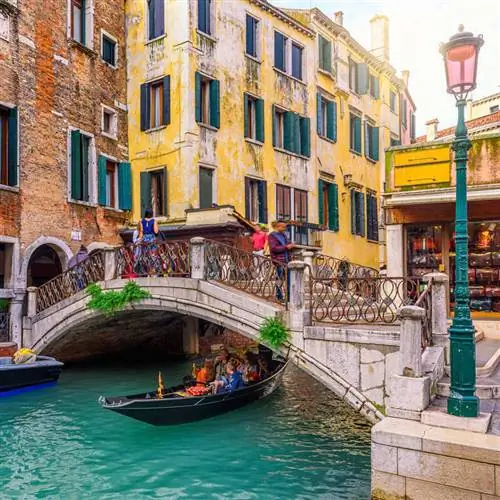 Гондола в узком канале с разноцветными домами в Венеции, Италия